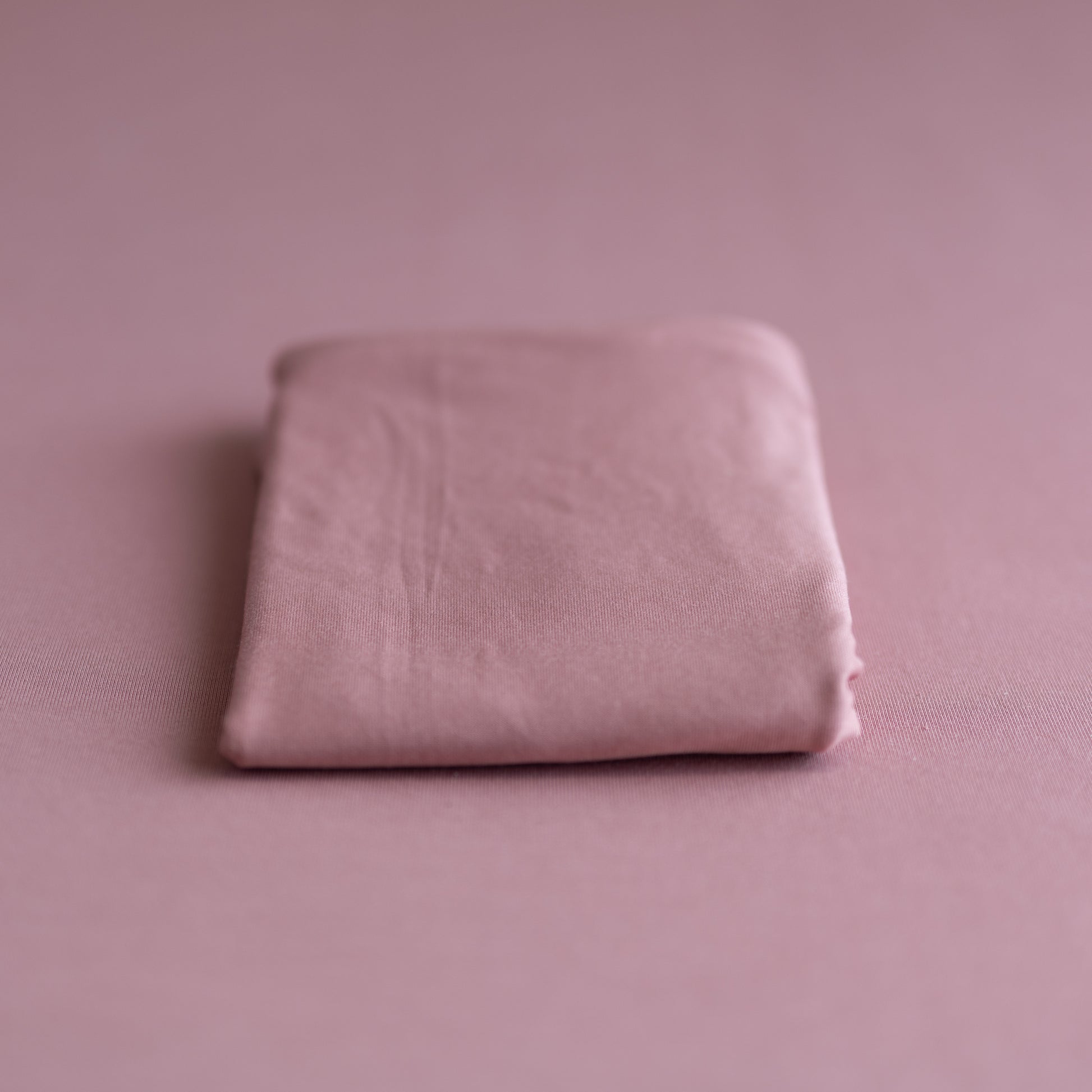 Folded pink fabric on a matching pink background