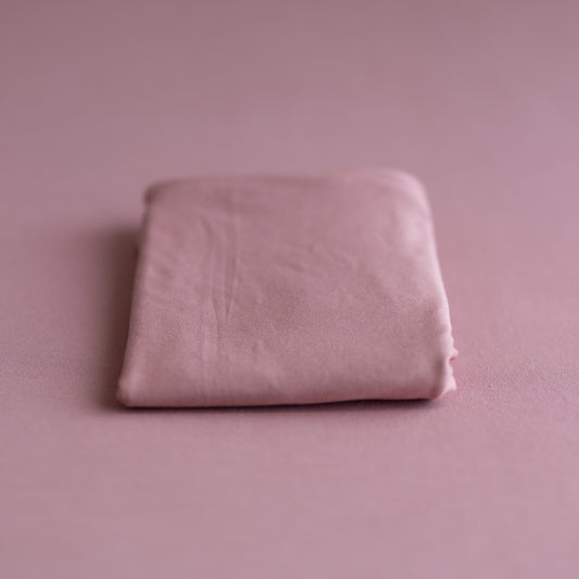 Folded pink fabric on a matching pink background